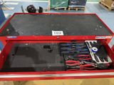 a red tool box with tools in it in a warehouse