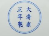 une assiette bleue et blanche sur laquelle figurent des caractères chinois