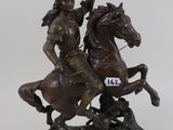 statue of a man riding a horse holding a flag on top of a base