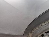a car that has been dented and is parked on the side of the road