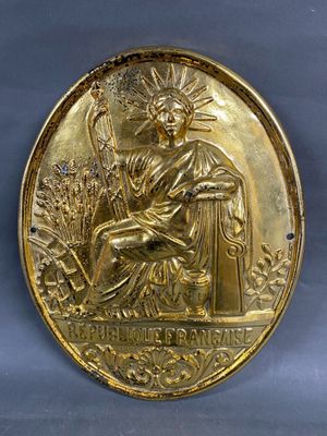 an image of a gold medal with the image of a woman holding a sword
