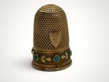 a close up of a thimble on a white surface
