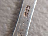 a silver spoon with writing on it sitting on a table