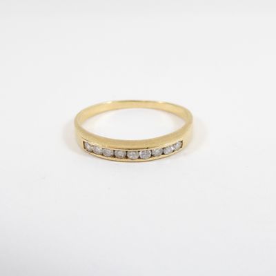 a yellow gold ring with three diamonds on a white background