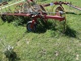 an image of a tractor with a hay raker attached to it