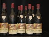 six bottles of wine are lined up in a row on a table