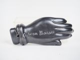 a black glove that is on a white surface
