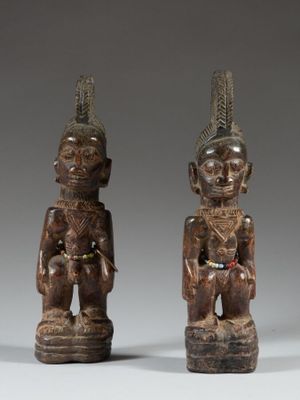 deux figurines en bois sculptées représentant un homme et une femme