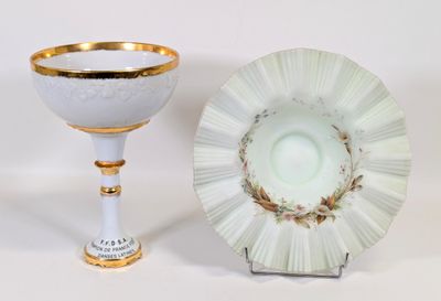 une tasse et une soucoupe blanches et dorées posées l'une à côté de l'autre