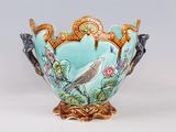 a vase with a bird on it sitting on a table
