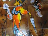 painting on the wall of a restaurant with a woman holding a knife