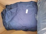 three t - shirts in a cardboard box on top of a bed