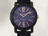 La montre est noire et dorée, avec un cadran bleu.