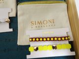 three bracelets in a box with a name tag on them