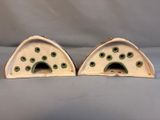 pair of white and green ceramic cat houses with holes in them