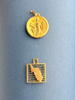 un gros plan sur une médaille d'or et une pièce d'or posées sur un fond bleu