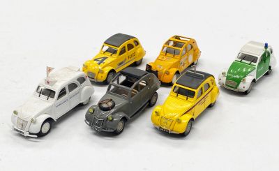 plusieurs petites voitures sont alignées sur une surface blanche