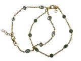 un gros plan sur un bracelet composé d'une chaîne en or et de perles de verre vertes