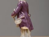 a figurine of a man in a purple coat and hat on a table