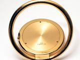 a gold clock that is on a white surface