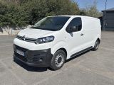 la camionnette blanche est garée sur un parking avec des arbres en arrière-plan