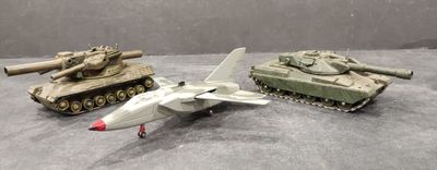 trois chars miniatures et un avion de chasse posés sur une table