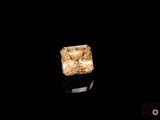 a close up of a yellow diamond on a black surface