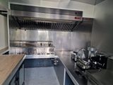 a large stainless steel kitchen with a stove and oven