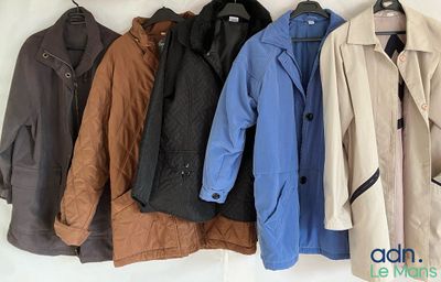 quatre manteaux accrochés au mur à côté d'un porte-manteau