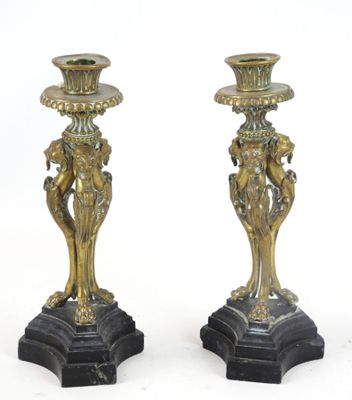 paire de bougeoirs anciens en laiton reposant sur des socles en marbre noir
