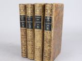 three old books sitting on top of each other on a white surface
