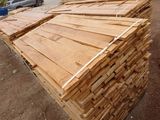 a pile of wood sitting on the ground in front of a building