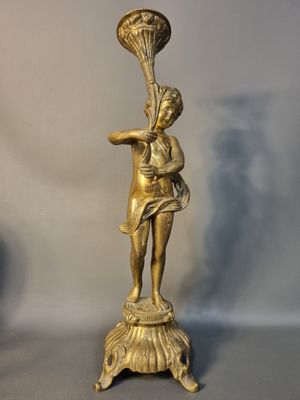 une statue représentant une femme tenant un éventail, posée sur une table
