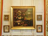 un tableau accroché au mur d'une pièce où sont accrochées des photos