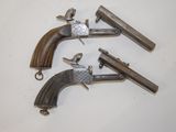 three old guns are sitting on a white surface, one of which is broken