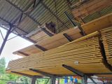 un banc en bois situé sous un auvent métallique