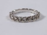 a close up of a diamond ring on a white surface