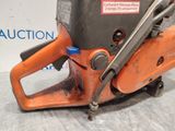 an orange chainsaw sitting on top of a table next to a sign