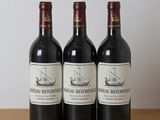 trois bouteilles de vin posées sur une table en bois