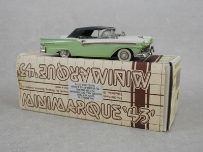 une petite voiture verte et blanche posée sur une boîte
