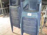 several blue plastic chairs are lined up in a row in a restaurant