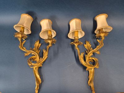 une paire d'appliques murales anciennes en laiton avec des abat-jours blancs