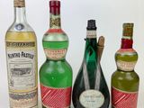 three bottles of alcohol are lined up on a white surface