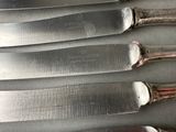 five knives that are sitting on top of a table