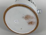 a white cup with a brown rim sitting on a table