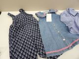 two dresses and a shirt are on a white table