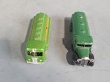 two green toy buses sitting next to each other on a table