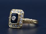 une image représentant une bague en or sertie d'une pierre bleue entourée de diamants blancs