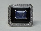 an image of a ring with a blue stone surrounded by diamonds