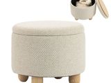 a white ottoman with wooden legs and a lid